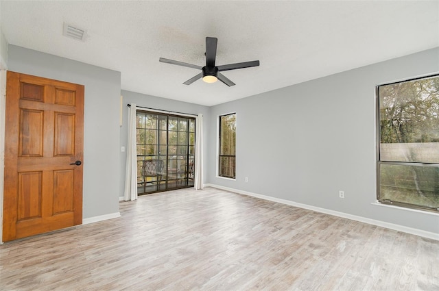 unfurnished room featuring ceiling fan, light hardwood / wood-style floors, and a textured ceiling