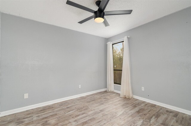 spare room with ceiling fan, a textured ceiling, and light wood-type flooring