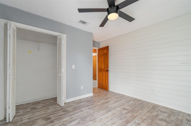 unfurnished bedroom with light hardwood / wood-style floors, a closet, and ceiling fan