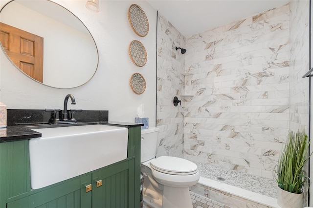 bathroom featuring vanity, tiled shower, and toilet