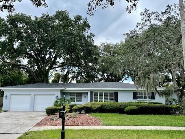 ranch-style home featuring a garage and a front yard