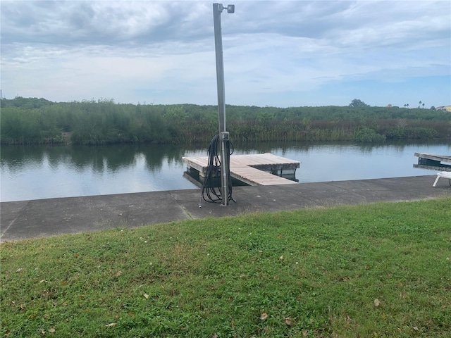 dock area featuring a lawn and a water view