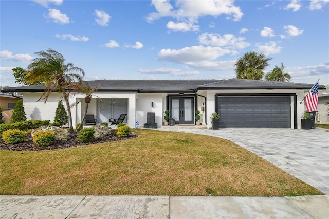 single story home with a garage, a front lawn, and french doors