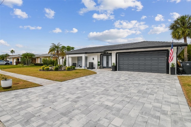 single story home featuring a garage and a front yard