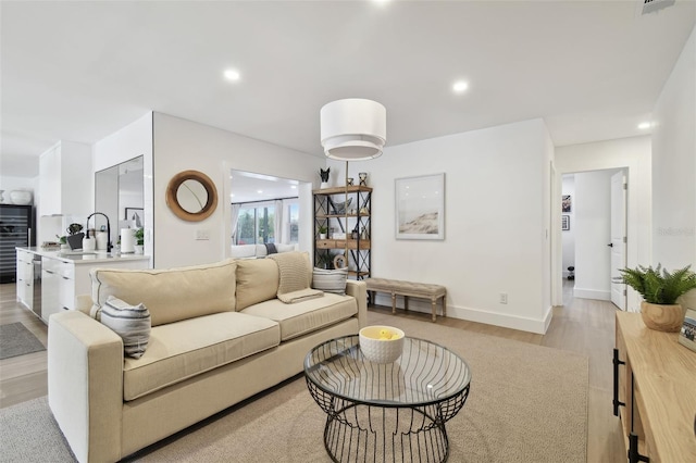 living room with sink and light wood-type flooring