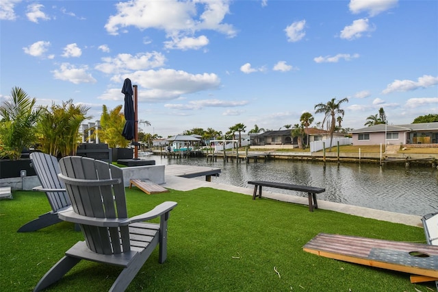 view of dock with a water view and a yard