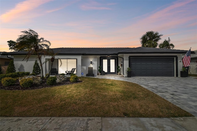 view of front of property with a yard and a garage