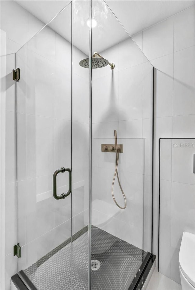 bathroom with toilet and an enclosed shower