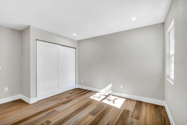 unfurnished bedroom with a closet and light hardwood / wood-style flooring