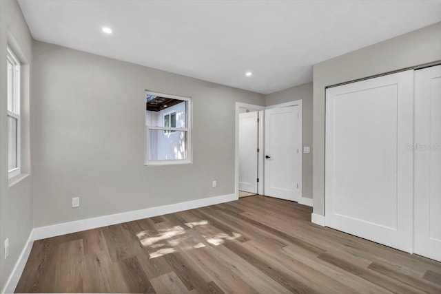 unfurnished bedroom with hardwood / wood-style flooring and a closet