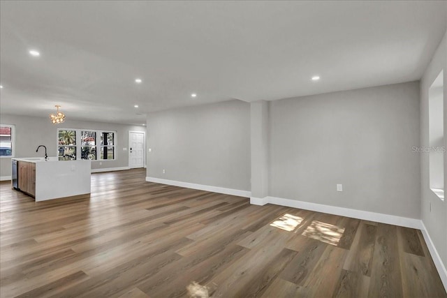 unfurnished living room with wood-type flooring and sink