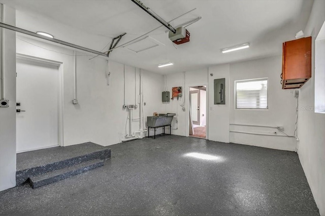 garage with sink, a garage door opener, and electric panel