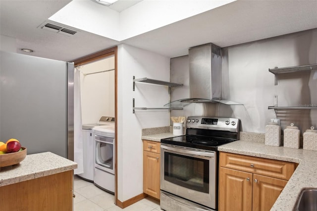 kitchen with washer and clothes dryer, light stone countertops, light tile patterned flooring, stainless steel electric stove, and exhaust hood