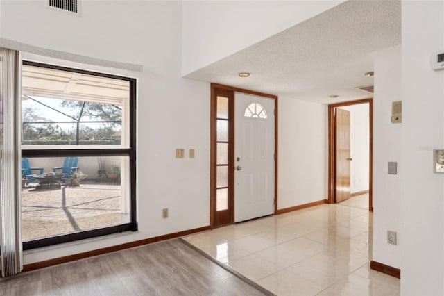 foyer featuring a textured ceiling and light tile patterned floors