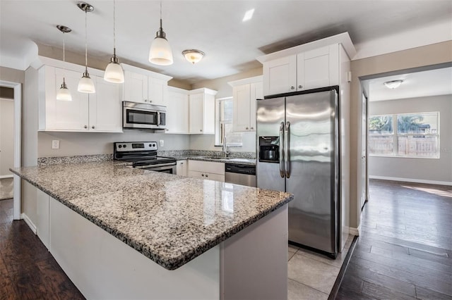 kitchen featuring white cabinetry, stainless steel appliances, and decorative light fixtures