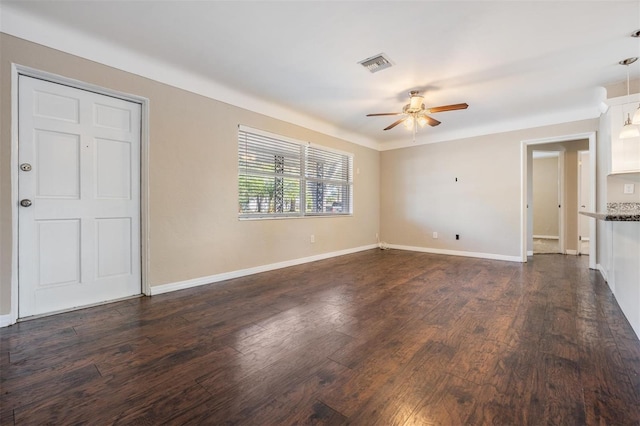 unfurnished living room featuring dark wood-type flooring and ceiling fan