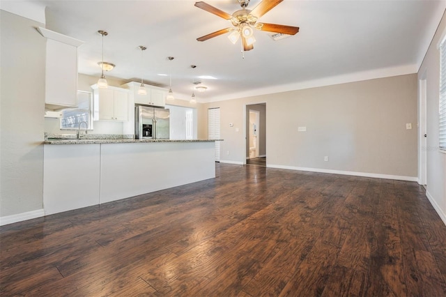 kitchen with pendant lighting, white cabinetry, stainless steel refrigerator with ice dispenser, light stone counters, and kitchen peninsula