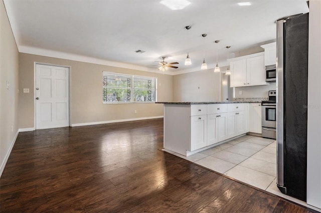 kitchen with decorative light fixtures, white cabinetry, ceiling fan, light stone counters, and stainless steel appliances