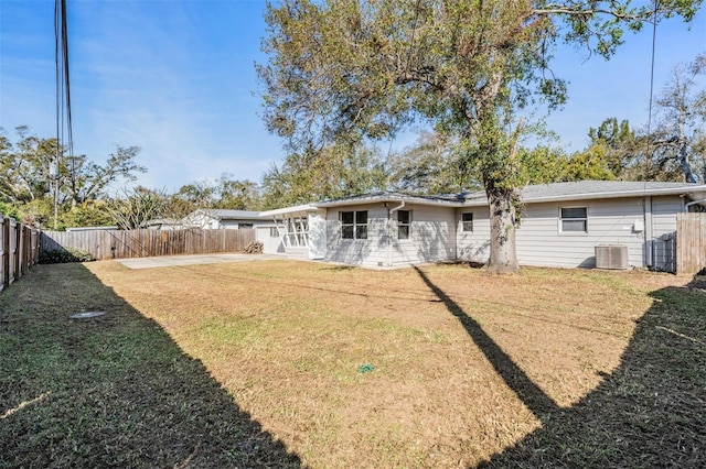 rear view of property with a yard and cooling unit