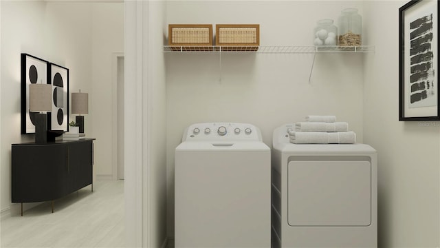 laundry area featuring washer and clothes dryer and light hardwood / wood-style flooring