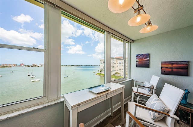 interior space with dark hardwood / wood-style flooring, a water view, and a textured ceiling