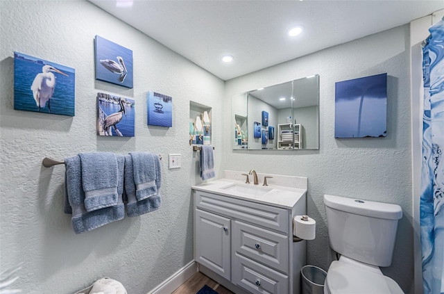 bathroom with vanity, hardwood / wood-style floors, and toilet