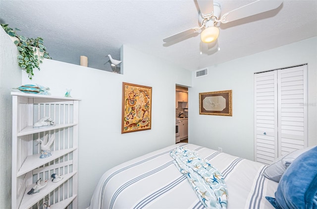 bedroom featuring ceiling fan, a closet, and a textured ceiling