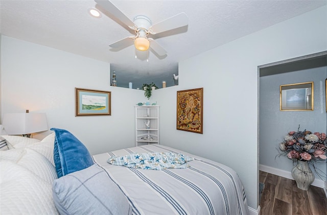 bedroom featuring ceiling fan, a textured ceiling, and dark hardwood / wood-style flooring