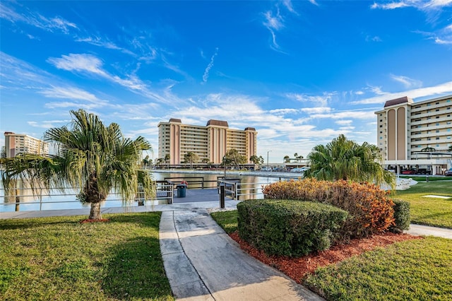 view of home's community with a water view and a lawn