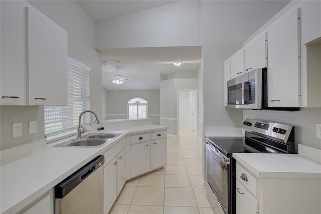 kitchen featuring light tile patterned flooring, sink, white cabinetry, appliances with stainless steel finishes, and ceiling fan