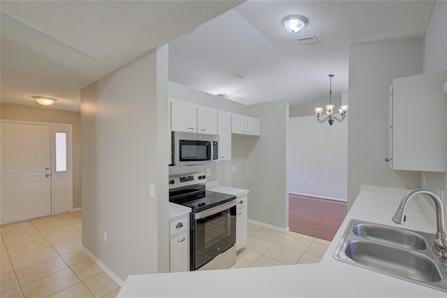 kitchen with pendant lighting, sink, white cabinets, light tile patterned floors, and stainless steel appliances