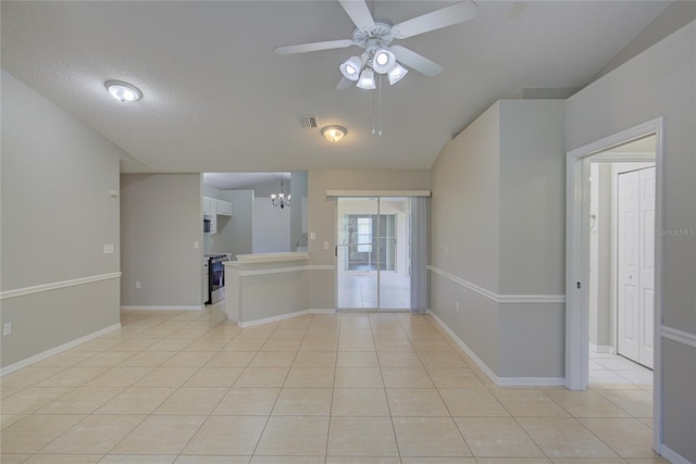 tiled empty room featuring ceiling fan with notable chandelier and a textured ceiling