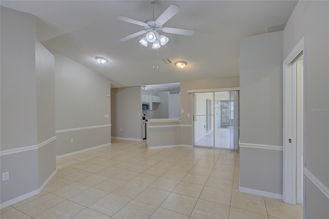 spare room with light tile patterned flooring, a textured ceiling, and ceiling fan