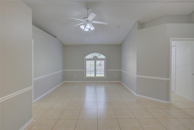 spare room with vaulted ceiling, light tile patterned floors, and ceiling fan