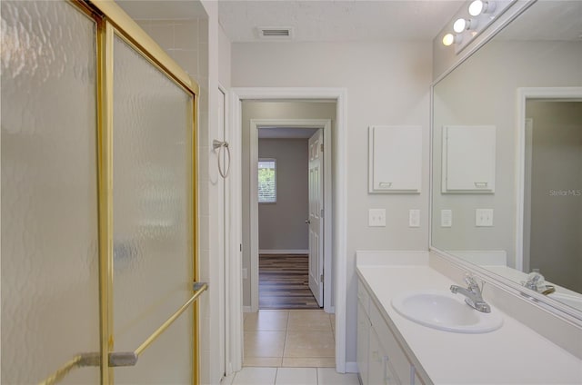 bathroom featuring an enclosed shower, vanity, and tile patterned floors