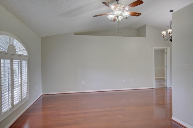 unfurnished room featuring dark wood-type flooring, vaulted ceiling, a textured ceiling, and ceiling fan with notable chandelier