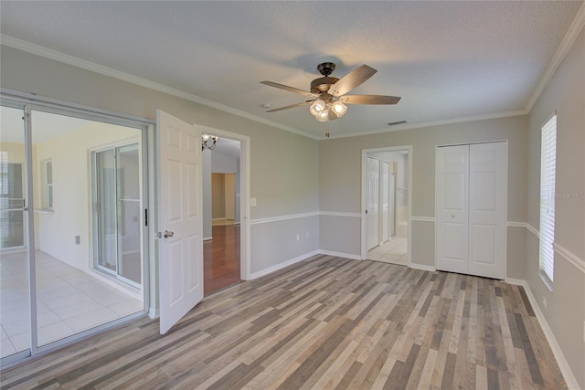 unfurnished bedroom with crown molding, a textured ceiling, a closet, ceiling fan, and light hardwood / wood-style floors