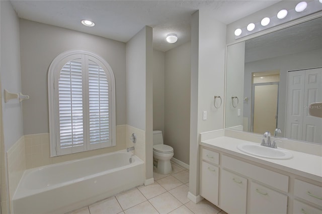 bathroom with tile patterned floors, toilet, a textured ceiling, vanity, and a bathtub