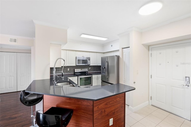 4516 Seagull Dr Unit 303, New Port Richey, FL 34652 - kitchen with stainless steel appliances, dark countertops, a peninsula, ornamental molding, and tasteful backsplash