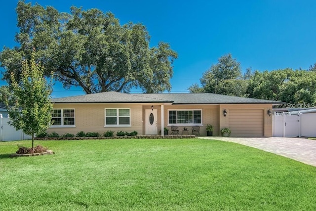 ranch-style home with a garage and a front lawn