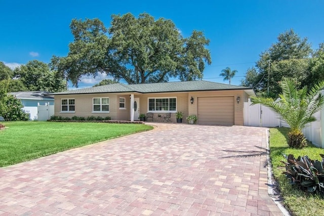 single story home featuring a garage and a front lawn