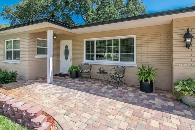 view of exterior entry with a patio