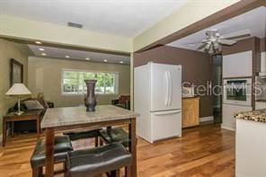 kitchen with white refrigerator and wood-type flooring