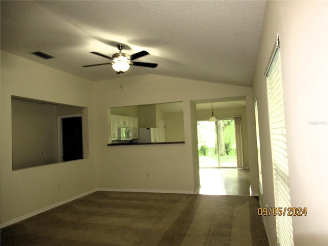 empty room with a textured ceiling, vaulted ceiling, and ceiling fan