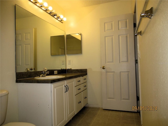 bathroom featuring vanity, tile patterned flooring, and toilet