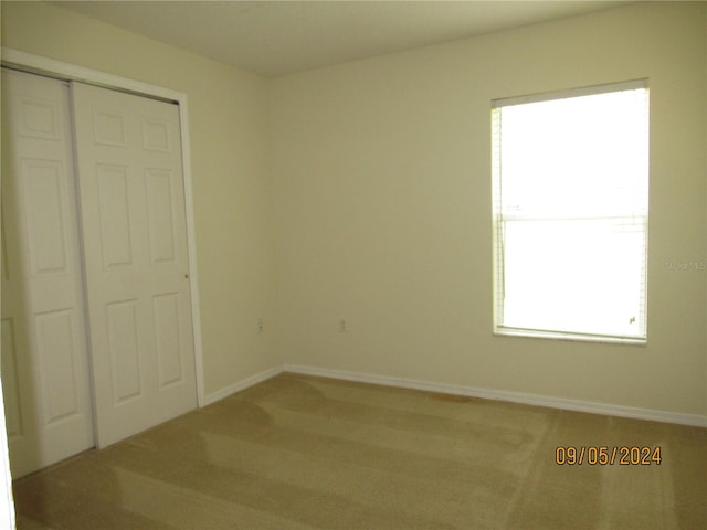 unfurnished bedroom with carpet floors and a closet