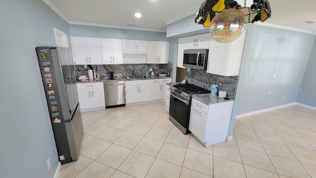 kitchen featuring white cabinetry, stainless steel appliances, light stone counters, ornamental molding, and decorative backsplash