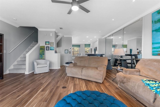 living room featuring wood-type flooring, ornamental molding, and ceiling fan