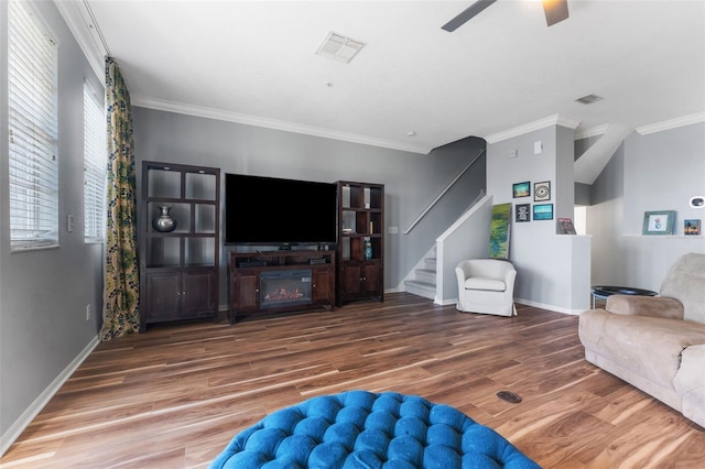 living room featuring hardwood / wood-style flooring, ornamental molding, and ceiling fan