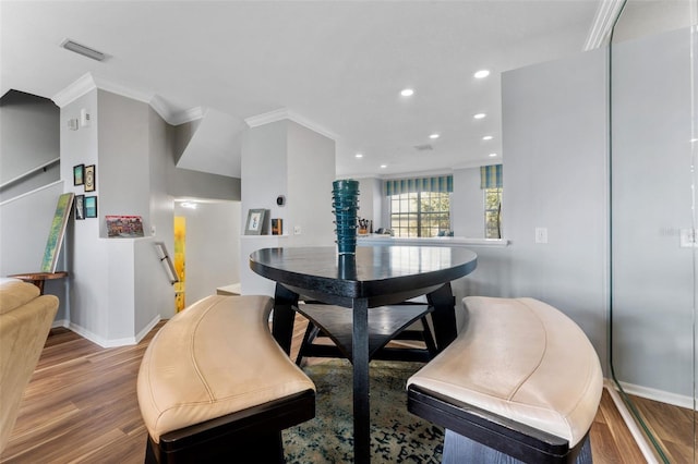 dining space with hardwood / wood-style flooring and ornamental molding